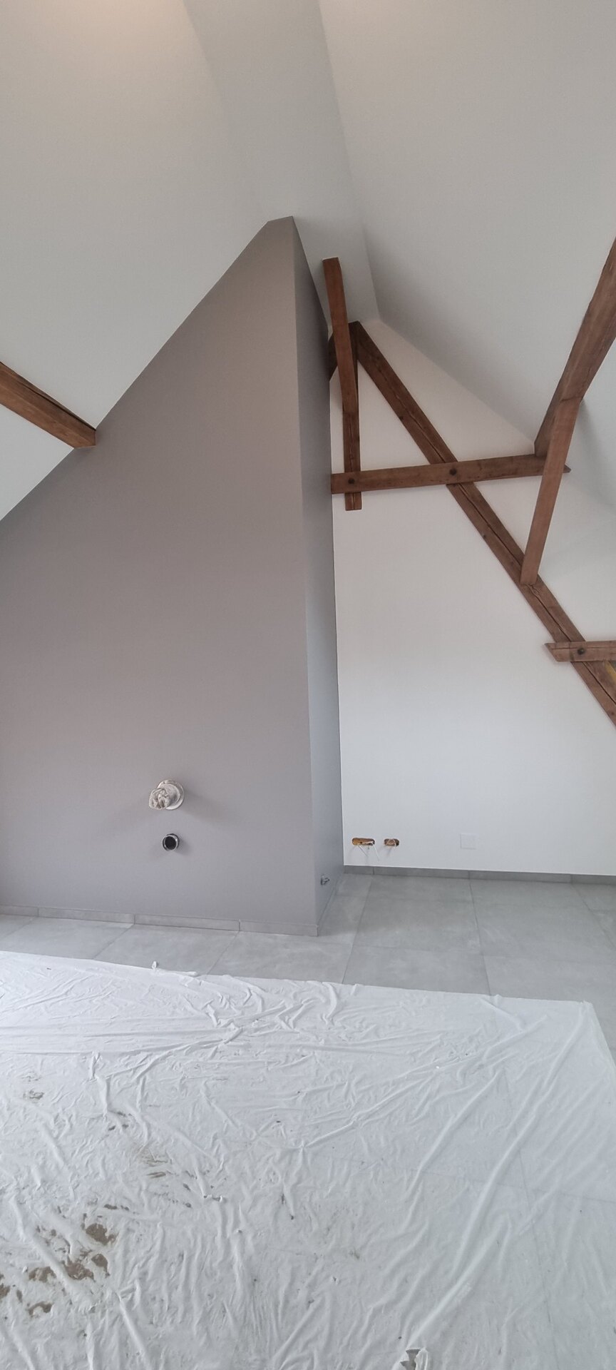 Mur gris et charpente bois après travaux de peinture intérieure